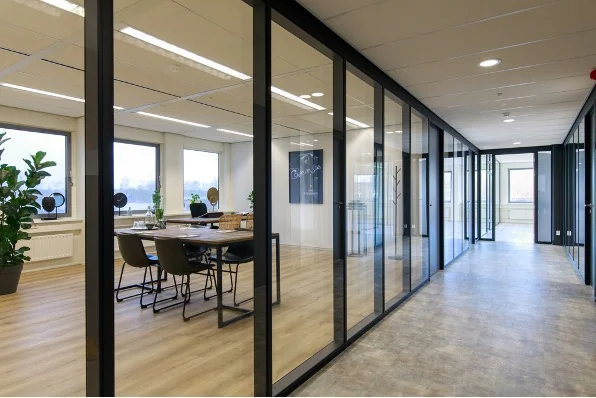 Moderne kantoorruimte aan de Baarnsche Dijk met glazen wanden en een vergaderruimte.